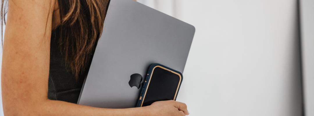 Woman holding laptop and cellphone